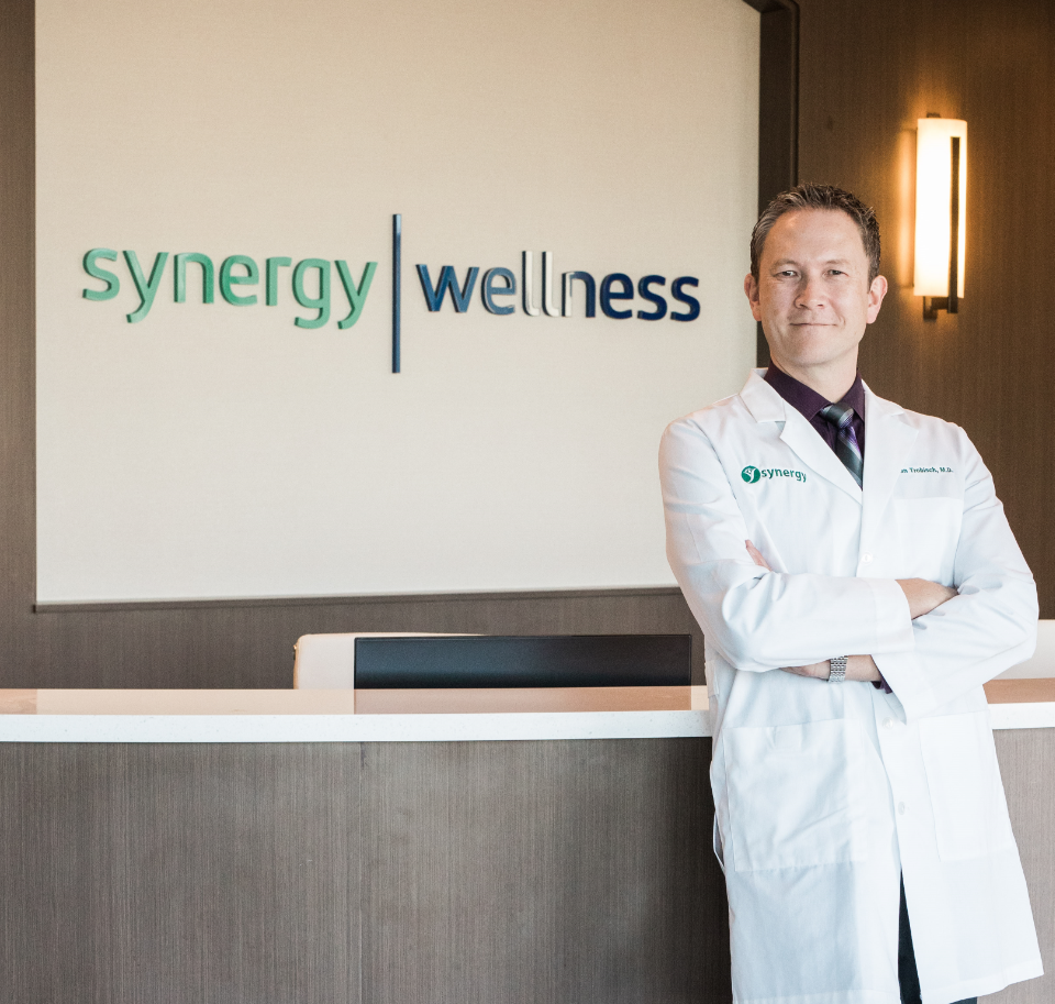 Dr. Trobisch Standing at Synergy Wellness Center Front Desk | Medical Aesthetics | Weight Loss Doctor | Body Shaping | Hormone Treatment | Bakersfield CA