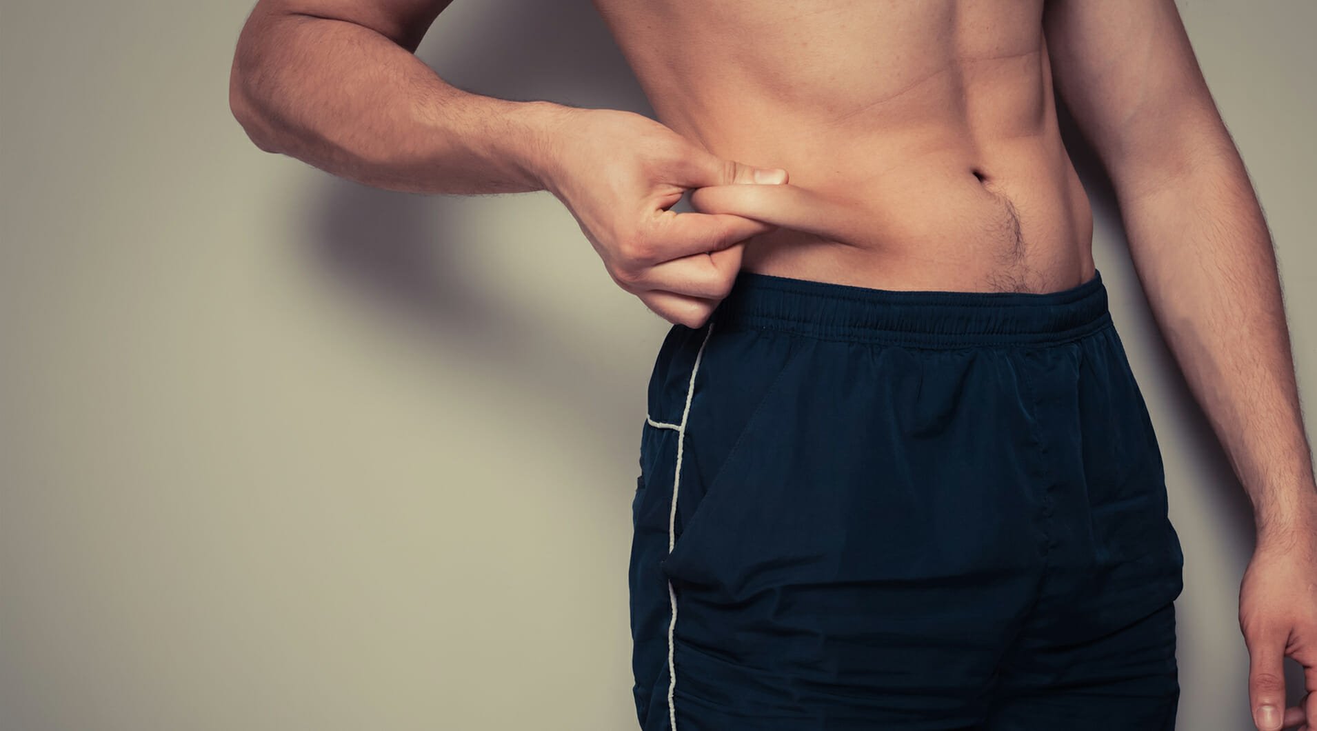 Man Grabbing Stomach Fat | Liposuction for Men - Bakersfield CA