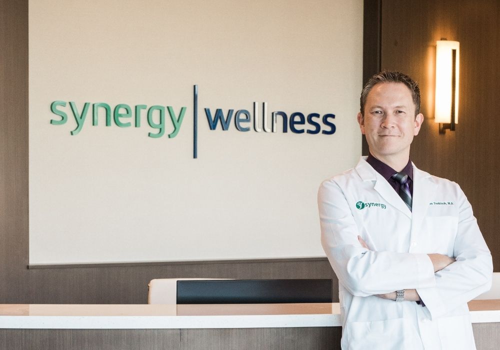 Dr. Trobisch standing at the Synergy Wellness reception desk