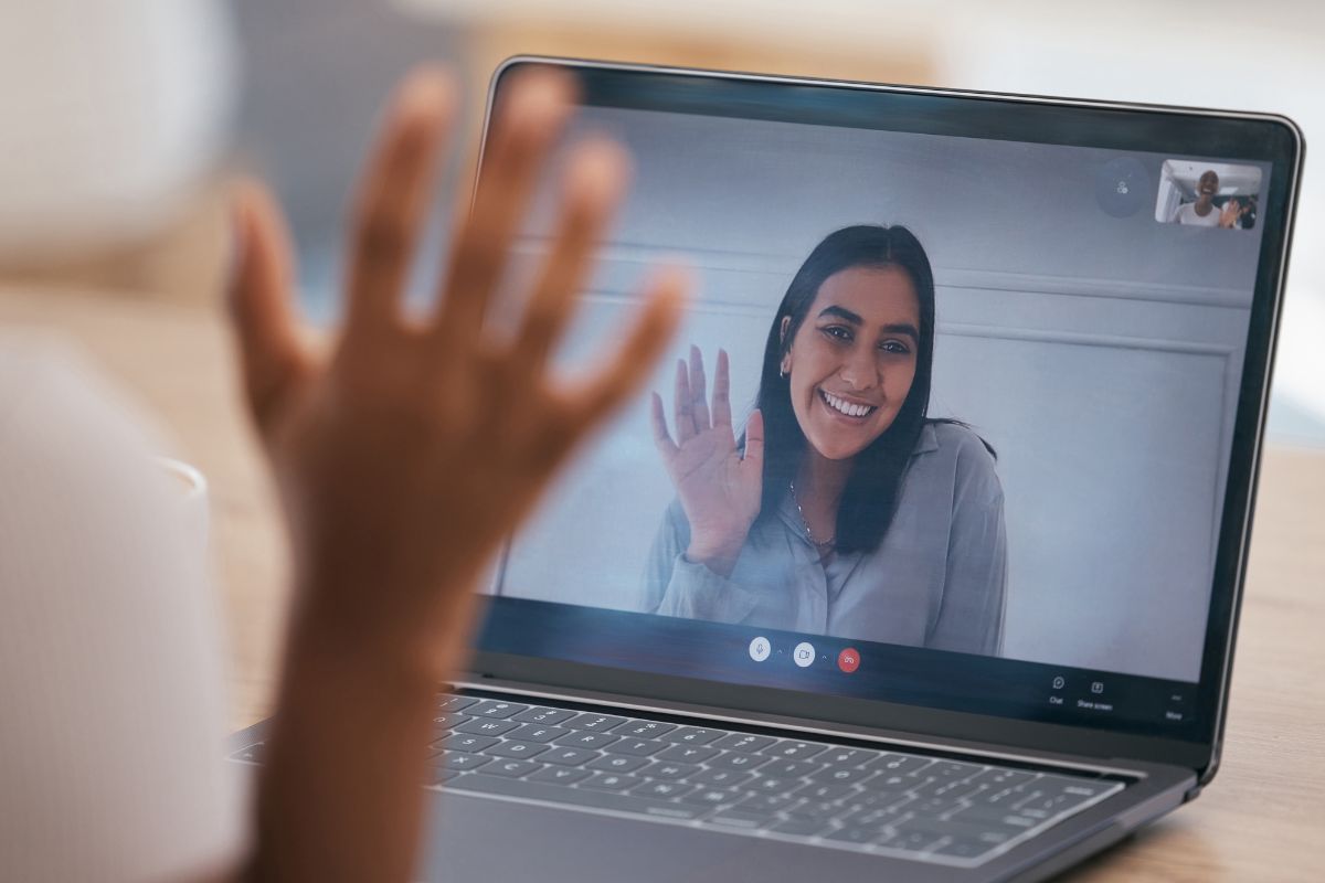 a woman waving at another woman on a video call